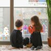 Adorable toddler boy and girl drawing animal on window glass